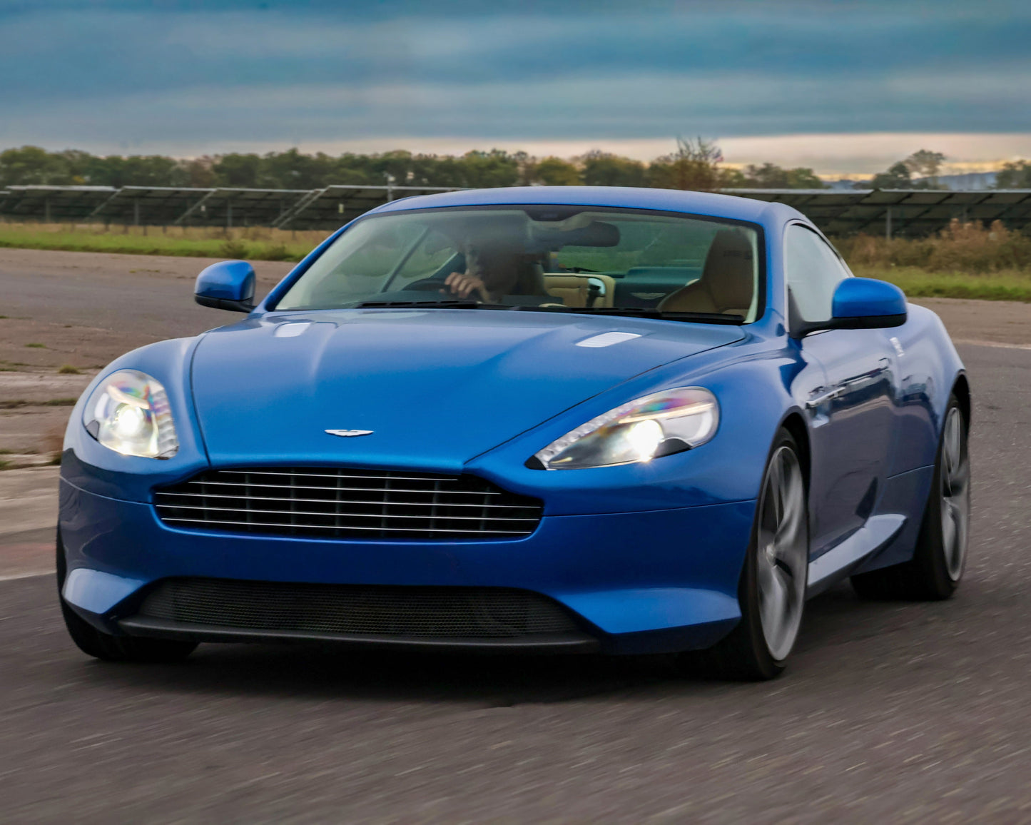 Blue Aston Martin car on a track with a blurred background