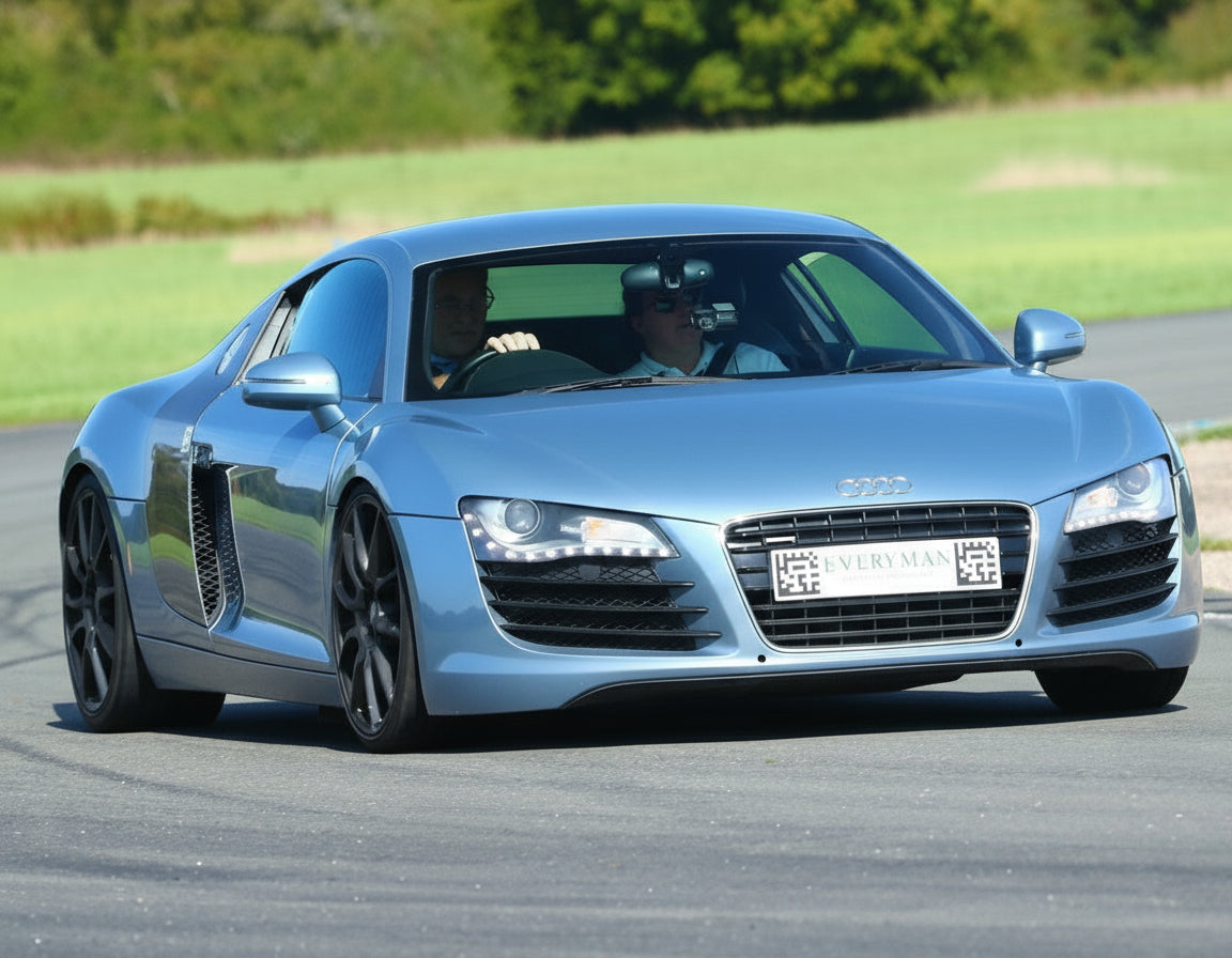 Blue Audi car on a track with a red cone