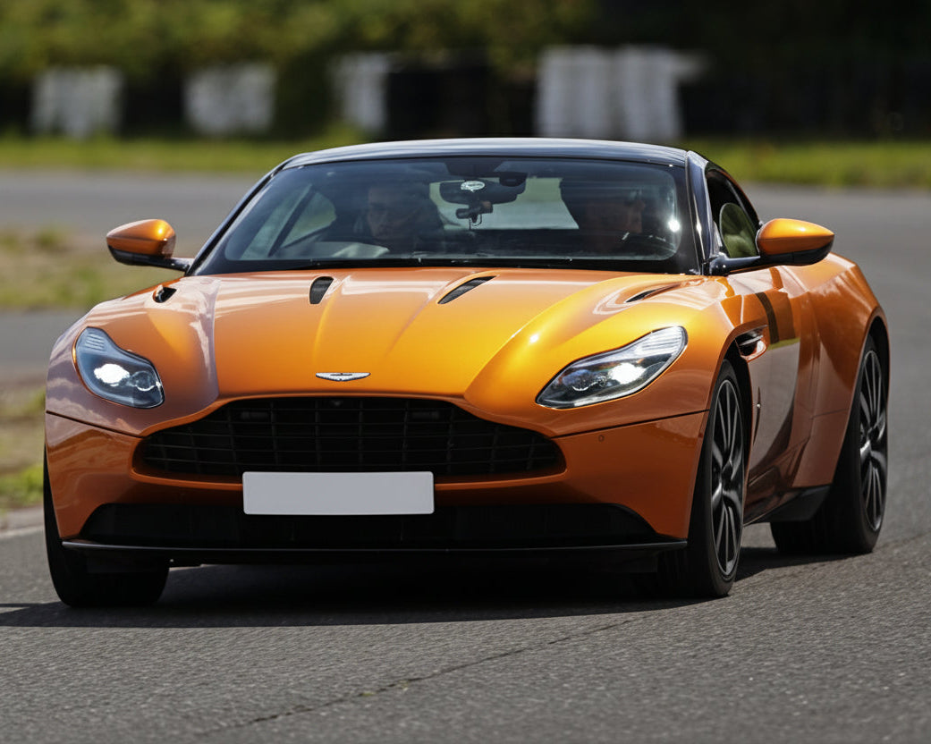 db11 Orange sports car on a road with blurred background